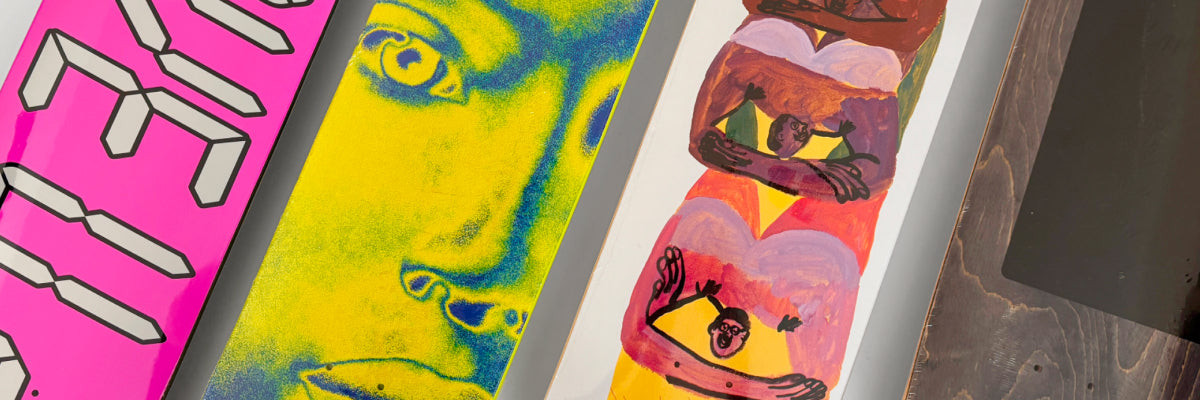 Four colorful askateboard decks side-by-side on a light surface. 